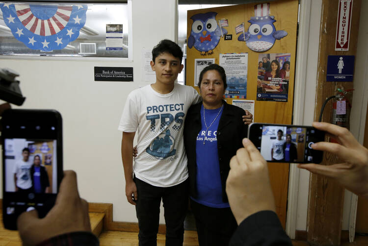 U.S. citizen Benjamin Zepeda, 14, with his mother Lorena Zepeda, who benefits from Temporary Protected Status, have their photo taken after a news conference in Los Angeles on Jan. 8. (AP Photo/Damian Dovarganes)