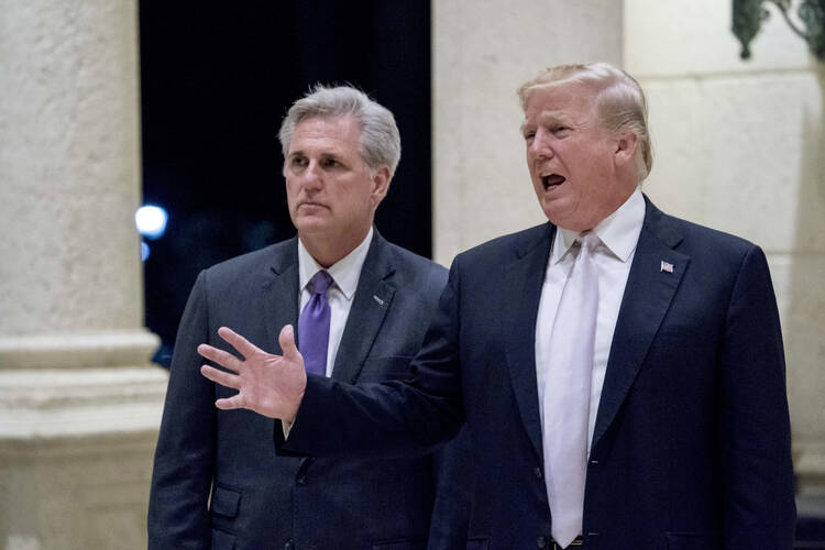 In this Jan. 14, 2018 photo, President Donald Trump, right, accompanied by House Majority Leader Kevin McCarthy, R-Calif., speaks to members of the media as they arrive for a dinner at Trump International Golf Club in West Palm Beach, Fla. Reinforcing its standing with social conservatives, the Trump administration creates a federal office to protect medical providers who refuse to participate in abortion, assisted suicide or other procedures because of their moral or religious beliefs. (AP Photo/Andrew Har