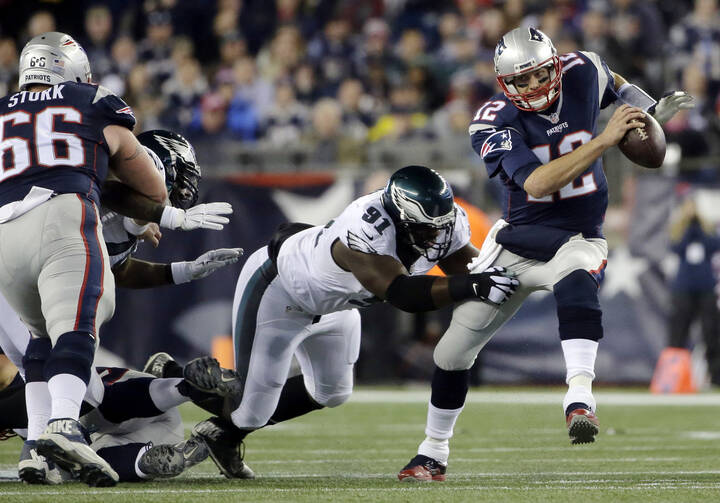 In this Dec. 6, 2015 photo, New England Patriots quarterback Tom Brady (12) scrambles away from Philadelphia Eagles defensive end Fletcher Cox (91) during a game in Foxborough, Mass. (AP Photo/Steven Senne, File).