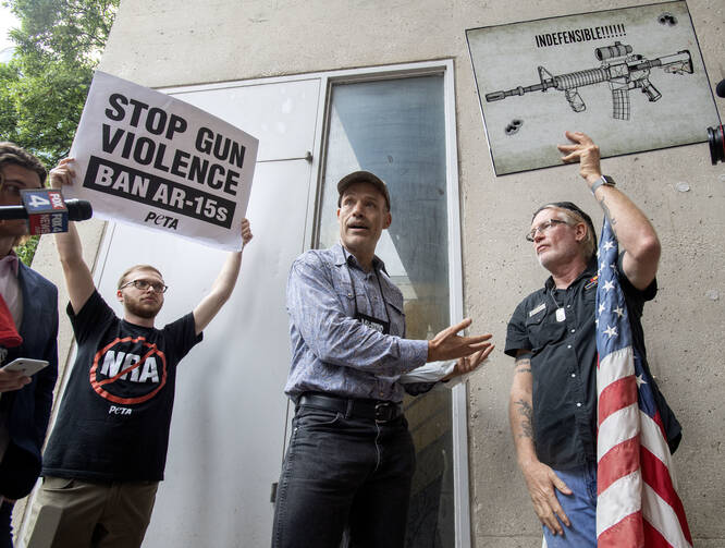 National Rifle Association member Jim Whelan, center, talks with protester David Lyles, right, outside the NRA Annual Meeting on May 4 in Dallas. (AP Photo/Jeffrey McWhorter)