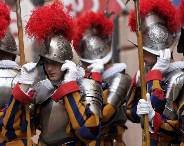 In this May 6, 2008 file photo, new Vatican Swiss Guards adjust their helmets prior to a swearing-in ceremony at the Vatican. The world’s oldest standing army is getting some new headgear. The Swiss Guards plan to replace their metal helmets with plastic PVC ones made with a 3-D printer, giving the pope's army cooler and more comfortable headgear when standing guard for hours at a time. (AP Photo/Alessandra Tarantino, pool)