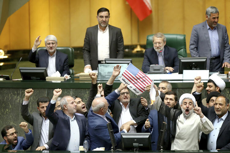 Iranian lawmakers burn papers representing the U.S. flag and the international nuclear agreement at the parliament in Tehran on May 9, following President Trump’s announcement that the United States will withdraw from the deal. (AP Photo)