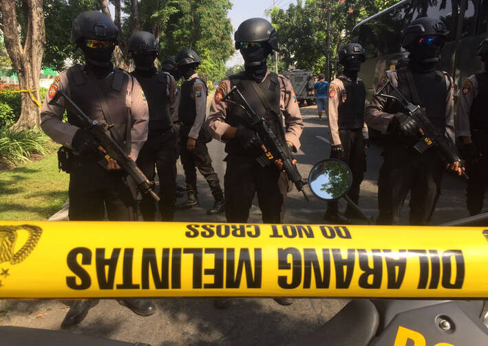 Police officers stand guard near the site where an explosion went off at Santa Maria church in Surabaya, East Java, Indonesia, Sunday, May 13, 2018. Media reports say simultaneous attacks on churches in Indonesia's second largest city of Surabaya have killed a number of people. (AP Photo/Trisnadi)