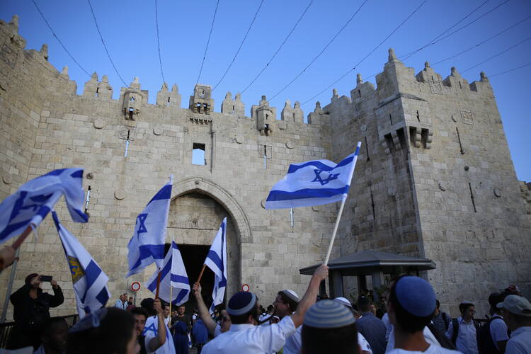 Israelis wave national flags outside the Old City's Damascus Gate, in Jerusalem, Sunday, May 13, 2018. Israel is marking the 51st anniversary of its capture of east Jerusalem in the 1967 Middle East war. (AP Photo/Ariel Schalit)