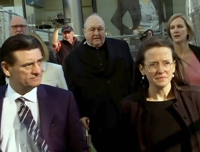 In this image made from video, Archbishop Philip Wilson, center, heads to Newcastle Local Court, north of Sydney, Australia Tuesday, May 22, 2018. (Australian Broadcasting Corporation via AP)