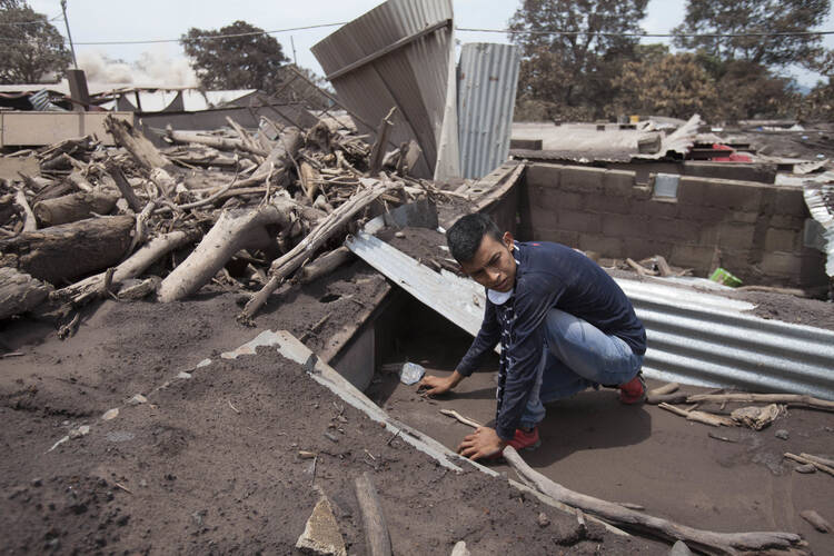 Bryan Rivera sifts through the remains of his house, after his family went missing during the Volcan de Fuego or "Volcano of Fire" eruption, in San Miguel Los Lotes, Guatemala, on June 7. (AP Photo/Moisés Castillo)