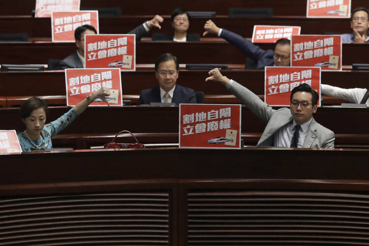 Pro-democracy lawmakers in Hong Kong react to the Legislative Council’s passage on June 14 of a bill giving China jurisdiction over a train station connecting the city to the mainland’s high-speed rail network. (AP Photo/Kin Cheung)