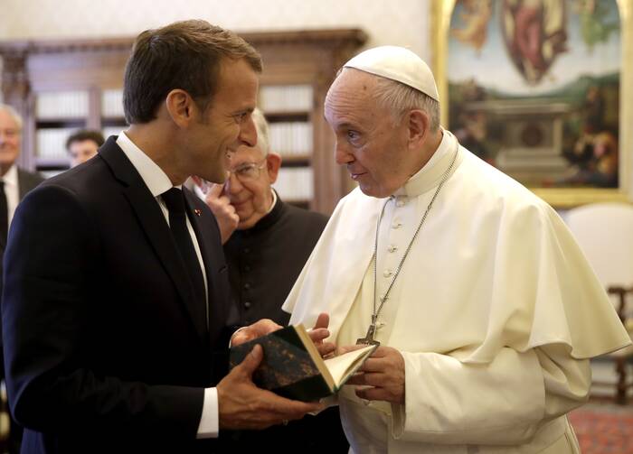 Pope Francis and with French President Emmanuel Macron, left, exchange gifts on the occasion of their private audience, at the Vatican, Tuesday, June 26, 2018. (Alessandra Tarantino/Pool Photo via AP)
