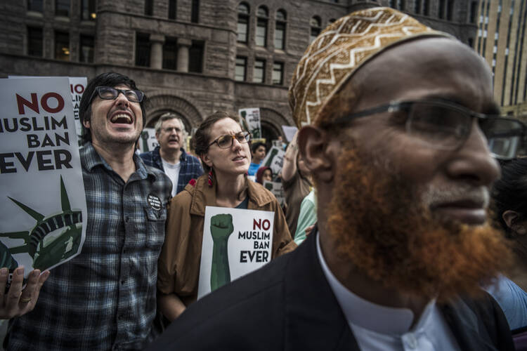 Abuturab Hashi, a Somali native, at right, was among the protesters of the Supreme Court's decision to uphold the Trump administration's travel ban outside the Federal Courthouse in Minneapolis on June 26. (Richard Tsong-Taatarii/Star Tribune via AP)