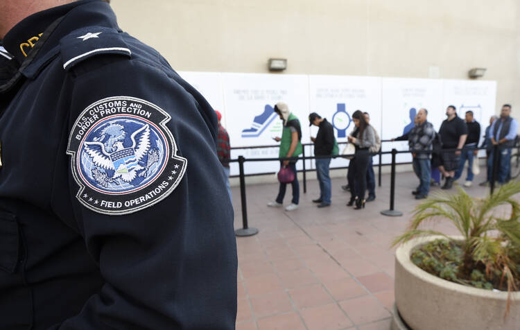 In this Dec. 10, 2015, file photo, pedestrians crossing from Mexico into the United States at the Otay Mesa Port of Entry wait in line in San Diego. (AP Photo/Denis Poroy, File)