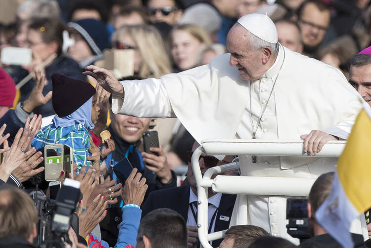 Pope Francis caresses a child as he arrives to celebrate a Mass in Freedom Square, in Tallinn, Estonia, Tuesday, Sept. 25, 2018. (AP Photo/Mindaugas Kulbis)