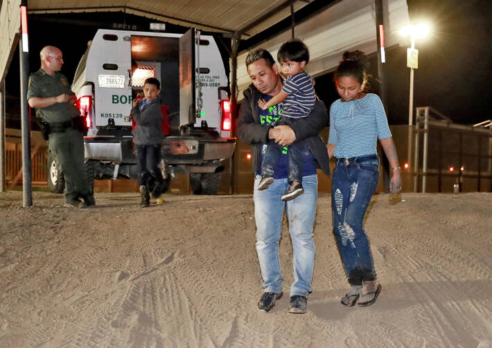 A Honduran man carries his 3-year-old son as his daughter and other son follow to a transport vehicle after being detained by U.S. Customs and Border Patrol agents in San Luis, Ariz., on July 18. Federal judges in California have challenged more of the Trump administration's "zero-tolerance" policy on illegal immigration. (AP Photo/Matt York, File)