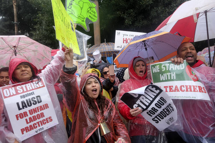 Teachers and supporters hold signs in the rain during a rally on Jan. 14 in Los Angeles. Thousands of Los Angeles teachers went on strike for the first time in three decades after contract negotiations failed in the nation's second-largest school district. (AP Photo/Ringo H.W. Chiu)