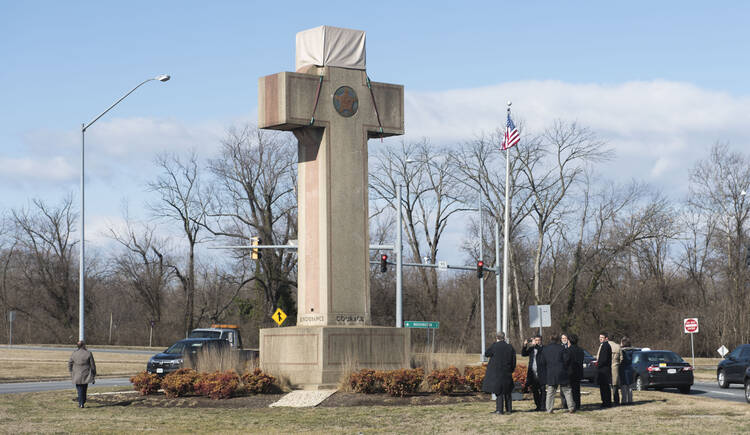 Visitors walk around the 40-foot Maryland Peace Cross dedicated to World War I soldiers on Wednesday, Feb. 13, 2019 in Bladensburg, Md. (AP Photo/Kevin Wolf)