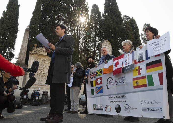 Child psychologist and founding member of the Ending Clergy Abuse (ECA) organization, Miguel Hurtado from Spain, center, reads an open letter to the Benedictine order outside the St. Anselm on the Aventine Benedictine complex in Rome on Feb. 22. (AP Photo/Domenico Stinellis)