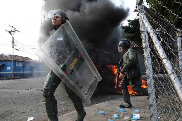 Officers of the Bolivarian National Guard clash with residents who cleared a barricaded border bridge attempting to bring humanitarian aid into the country, in Urena, Venezuela, near the border with Colombia, on Feb. 23. (AP Photo/Rodrigo Abd, File)