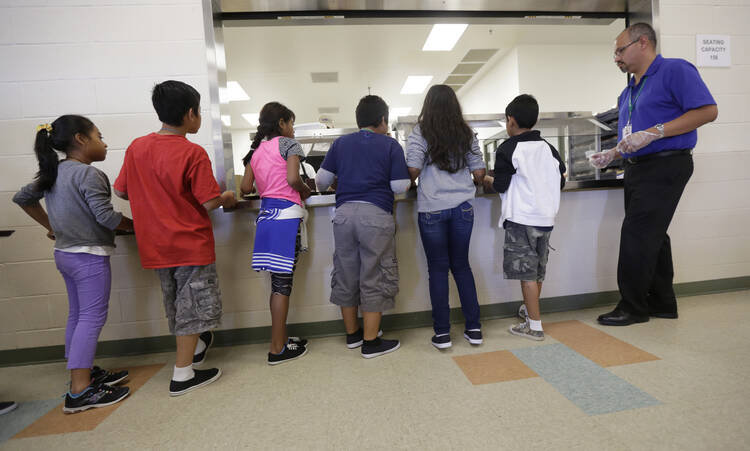 Detained immigrant children line up in the cafeteria in this Sept. 10, 2014 file photo at the Karnes County Residential Center, a detention center for immigrant families operated by the GEO Group in Karnes City, Texas. (AP Photo/Eric Gay, File)