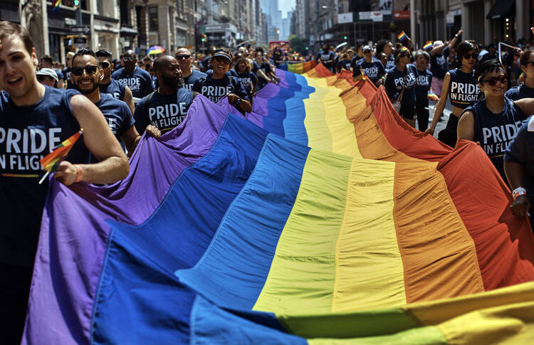 Revelers carry a rainbow flag along Fifth Avenue during the L.G.B.T. Pride Parade in New York on June 24, 2018. (AP Photo/Andres Kudacki, File)