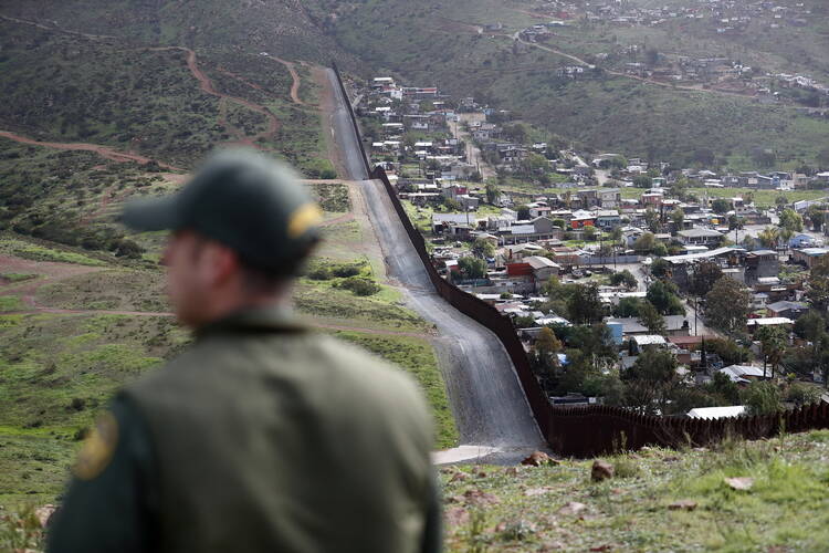 In this Feb. 5, 2019, file photo, Border Patrol agent Vincent Pirro looks on near a border wall that separates the cities of Tijuana, Mexico, and San Diego, in San Diego. (AP Photo/Gregory Bull, File)