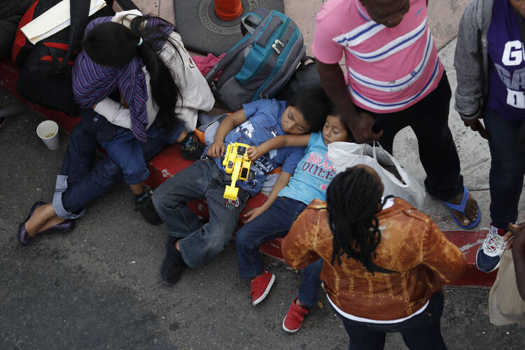 People wait to apply for asylum in the United States along the border on July 16 in Tijuana, Mexico. (AP Photo/Gregory Bull)