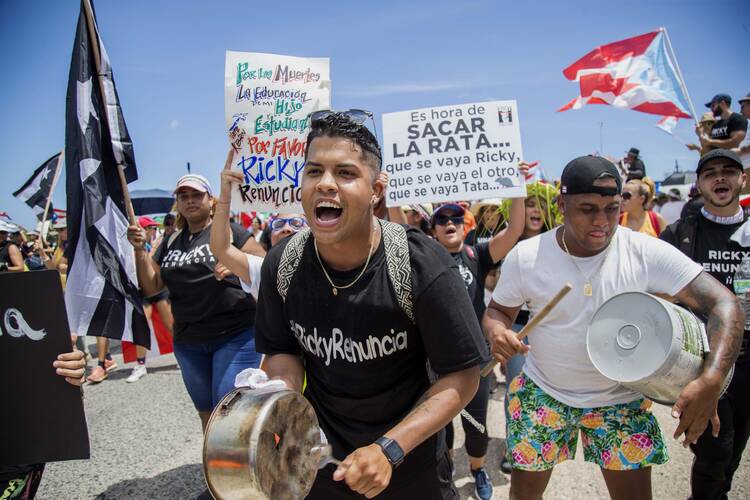 Demonstrators bang on pots and buckets as they march on Las Americas highway demanding the resignation of governor Ricardo Rossello, in San Juan, Puerto Rico, on July 22. (AP Photo/Dennis M. Rivera Pichardo)