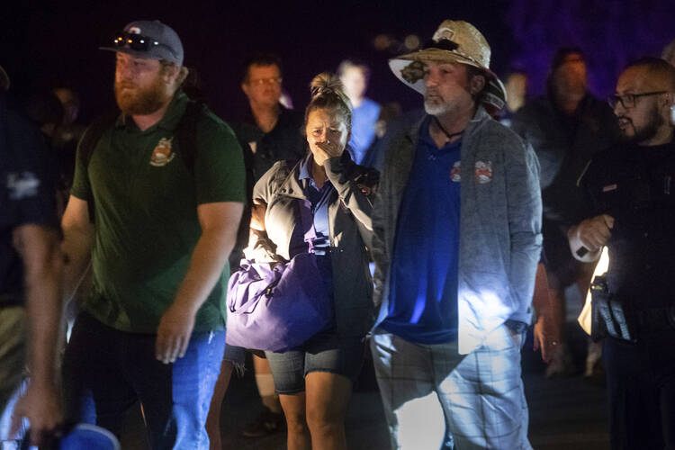 Police officers escort people from Christmas Hill Park following a deadly shooting during the Gilroy Garlic Festival, in Gilroy, Calif., on Sunday, July 28, 2019. (AP Photo/Noah Berger)