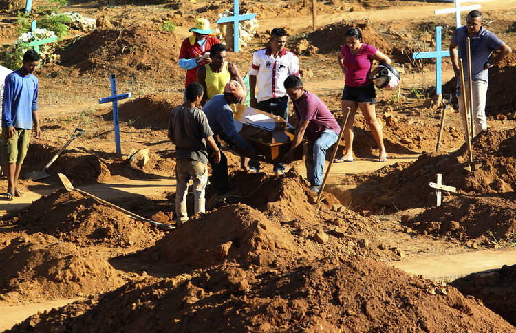 People bury a prisoner who was killed during a prison riot in Altamaria, Para state, Brazil, on July 31. Grieving families began to arrive that day at the cemetery of Altamira to mourn some of the 58 inmates killed by a rival gang in a grisly prison riot. (AP Photo/Raimundo Pacco)