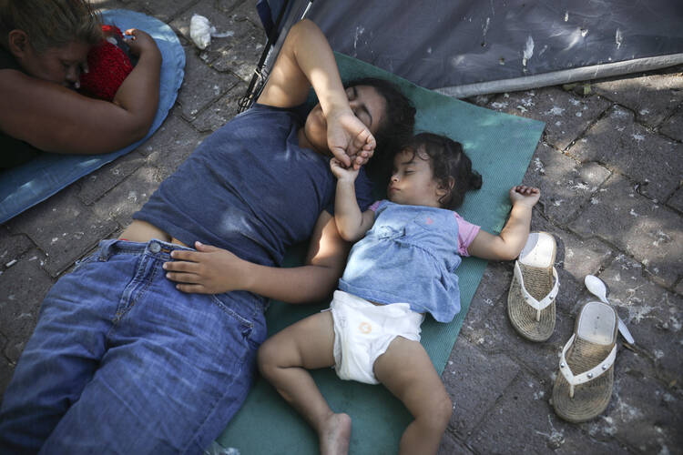 Migrants rest near a Mexican immigration center where migrants set up camp in Matamoros, Mexico, on Aug. 1. Turning Mexican border cities into waiting rooms for asylum seekers may be the Trump administration’s most forceful response yet to a surge of migrants, many of them Central American families. (AP Photo/Emilio Espejel)