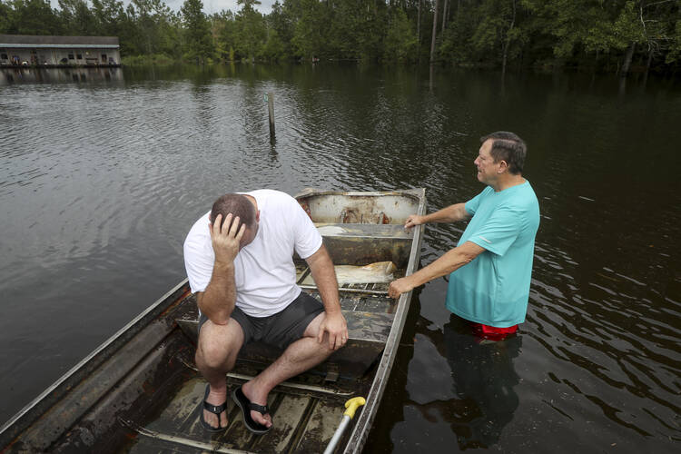 Stephen Gilbert, left, and his father-in-law sit in front of their flooded property on Sept. 20 in the Mauriceville, Texas, area. Floodwaters are starting to recede in most of the Houston area after the remnants of Tropical Storm Imelda flooded parts of Texas. Imelda will likely be Southeast Texas’ fifth 500-year flood event in as many years. ( Jon Shapley/Houston Chronicle via AP)
