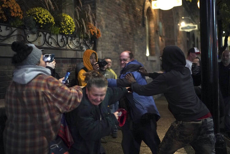 A Trump supporter reacts after a protester grabs the hat off his head outside the Target Center in Minneapolis, following a campaign rally led by President Donald Trump on Oct. 10. (Renee Jones Schneider/Star Tribune via AP)