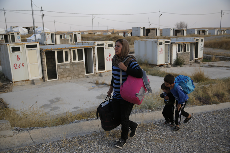 Image: Salwa Hanna with her children arrive at the Bardarash refugee camp, north of Mosul, Iraq, on Oct. 17. Christians originally from Afrin, Ms. Hanna’s family has now been displaced twice by Turkish incursions. “I left my home, and I had just started a new home, and I left it all behind,” she said. “There are no emotions anymore. We live as if we are dead.” (AP Photo/Hussein Malla)