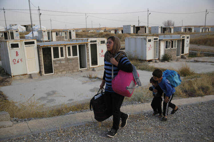 Salwa Hanna with her children arrive at the Bardarash refugee camp, north of Mosul, Iraq, on Oct. 17. Christians originally from Afrin, Ms. Hanna’s family has now been displaced twice by Turkish incursions. “I left my home, and I had just started a new home, and I left it all behind,” she said. “There are no emotions anymore. We live as if we are dead.” (AP Photo/Hussein Malla)