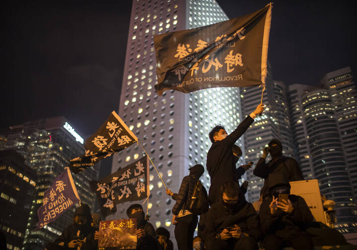 A protestor holds a flag that reads: "Liberate Hong Kong, Revolution of Our Times" at a rally in Hong Kong on Dec. 12. Protesters wrote hundreds of Christmas cards for detainees jailed during the city's pro-democracy movement. (AP Photo/Mark Schiefelbein)