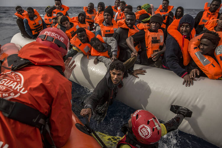 In this Sunday, Feb 18, 2018 file photo, refugees and migrants are rescued by aid workers of the Spanish NGO Proactiva Open Arms, after leaving Libya trying to reach European soil aboard an overcrowded rubber boat, 60 miles north of Al-Khums, Libya. (AP Photo/Olmo Calvo, file)