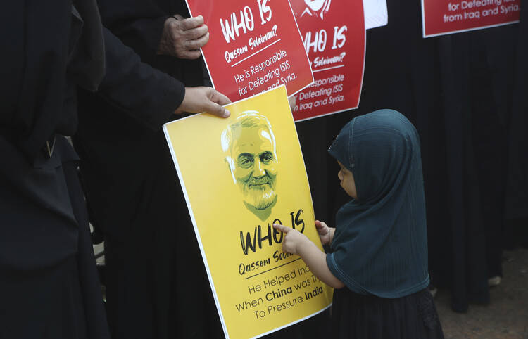 A Shiite Muslim girl points at a portrait of Iranian Gen. Qassem Soleimani, who was killed in a U.S. attack, during a protest against the United States in Mumbai, India, on Jan. 9. (AP Photo/Rafiq Maqbool)
