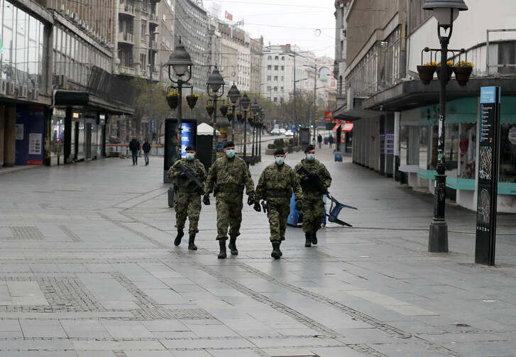 In this March 26, 2020, photo, Serbian army soldiers patrol Belgrade’s main pedestrian street as part of the government’s efforts to contain the coronavirus pandemic. (AP Photo/Darko Vojinovic)