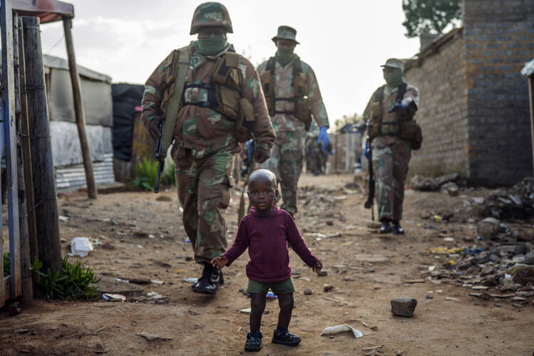 South African National Defense Forces patrol the Sjwetla informal settlement after pushing back residents into their homes on the outskirts of the Alexandra township in Johannesburg, on April 20. The residents were protesting the lack of food. (AP Photo/Jerome Delay)
