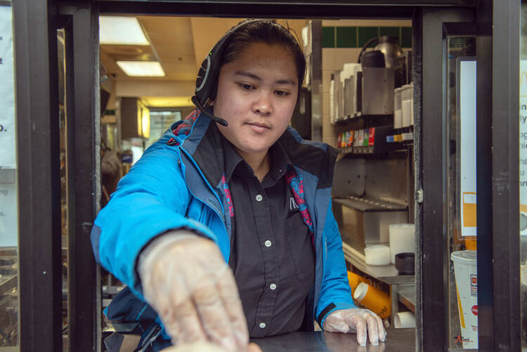 Milagrose Sarmiento works the drive-through window at a McDonald’s restaurant in Sitka, Alaska, on April 24. Low-paid workers such as restaurant employees are proving their value during the coronavirus pandemic. (James Poulson/The Daily Sitka Sentinel via AP)