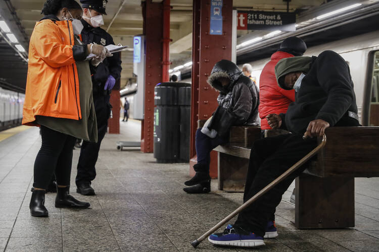 Homeless outreach personnel assist passengers found sleeping on subway cars in New York City on April 30. New York has the highest income inequality among the 50 states, comparable to the inequality in the nation of Angola. (AP Photo/John Minchillo, File)