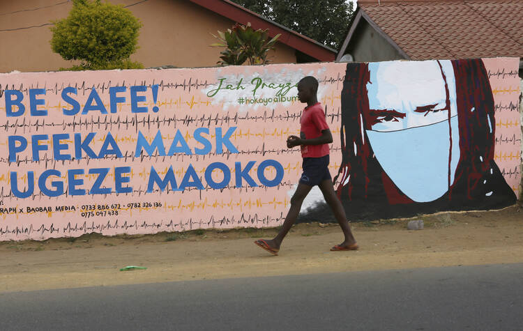 A young boy walks past a wall with graffiti urging people to wear face masks in Harare, on May 28. Manhunts have begun after hundreds of people fled quarantine centres in Zimbabwe and Malawi. Authorities worry they will spread COVID-19 in countries whose health systems can be rapidly overwhelmed. (AP Photo/Tsvangirayi Mukwazhi)