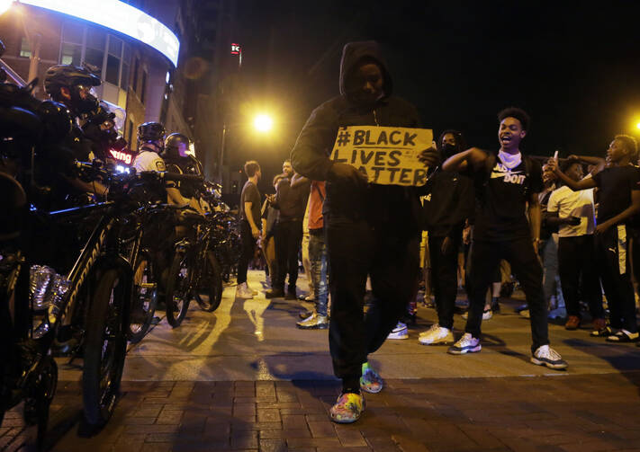 Protesters walk past a line of police in downtown Columbus, Ohio, on Thursday during a demonstration over the death of George Floyd in police custody Monday in Minneapolis. (Barbara J. Perenic/The Columbus Dispatch via AP)