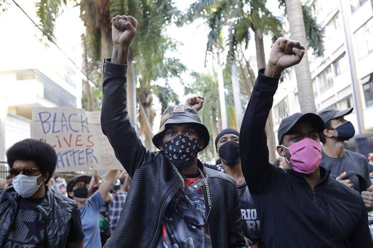 People protest against crimes committed by the police against black people in the favelas, outside the Rio de Janeiro's state government, Brazil, Sunday, on May 31. (AP Photo/Silvia Izquierdo)