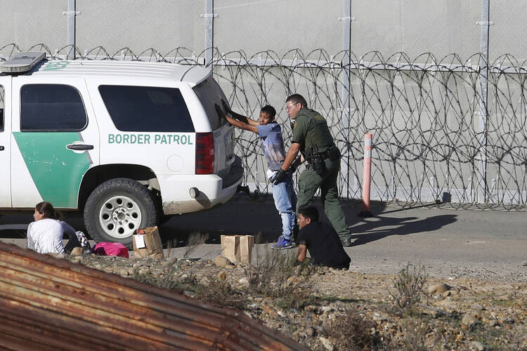 In this Dec. 15, 2018, file photo, Honduran asylum seekers are taken into custody by U.S. Border Patrol agents in San Diego. (AP Photo/Moises Castillo, File)