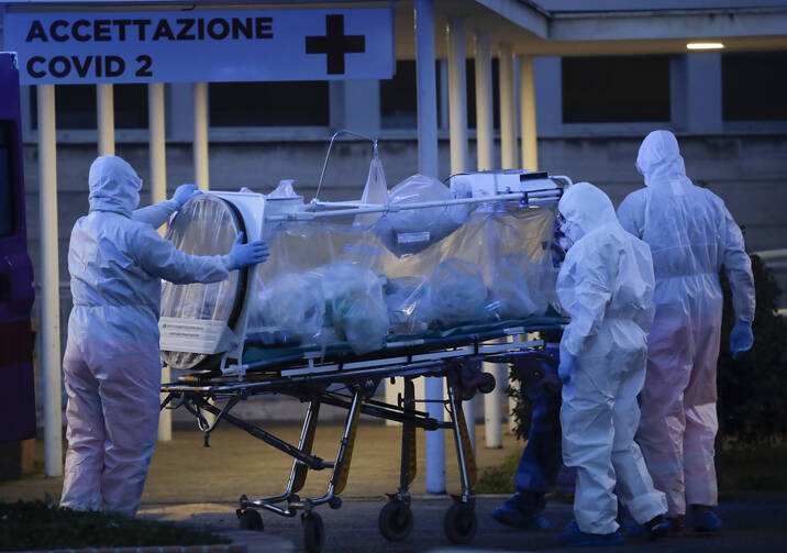 A patient in a biocontainment unit is carried on a stretcher at the Columbus Covid 2 Hospital in Rome, Monday, March 16, 2020. (AP Photo/Alessandra Tarantino)