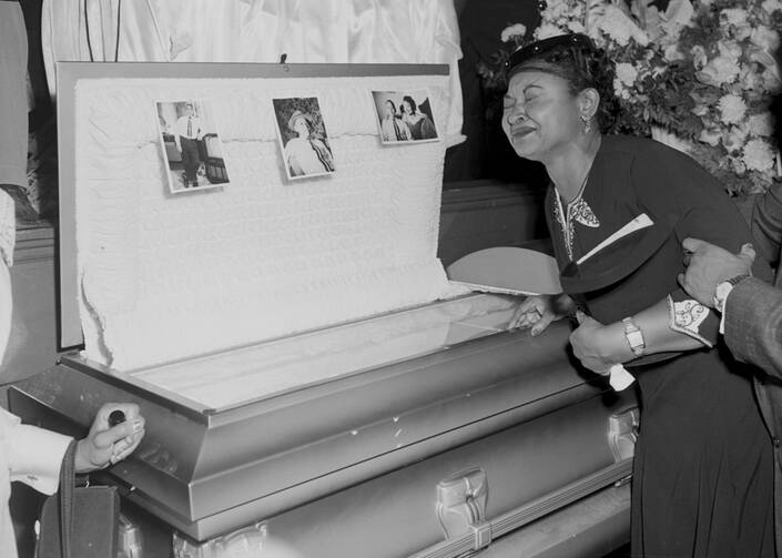 In this 1955 file photo, Mamie Bradley, mother of Emmett Till, pauses at her son's casket at a Chicago funeral home. 