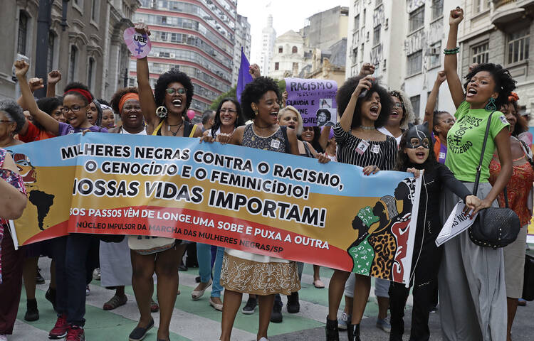 Activists march holding a banner that reads in Portuguese “Black women against racism, genocide and femicide. Our lives matter,” during a demonstration to mark International Women’s Day, in Sao Paulo, Brazil, on March 8, 2017. (AP Photo/Andre Penner)