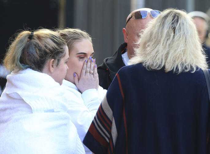 Fan leaves the Park Inn hotel in central Manchester, England, on Tuesday, May 23, 2017. Over a dozen people were killed in an explosion following a Ariana Grande concert at the Manchester Arena late Monday evening. (AP Photo/Rui Vieira)