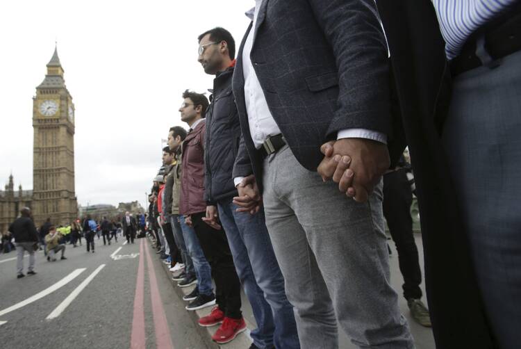 Londoners link hands during a commemorative event to mark last week's attack outside Parliament on Westminster Bridge on March 29. (Yui Mok/PA via AP)