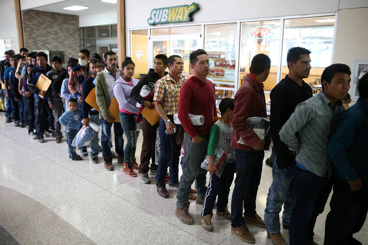 Immigrants just released from detention via a U.S. immigration policy known as "catch and release" stand at a bus station April 11 before being taken to the Catholic Charities relief center in McAllen, Texas. (CNS photo/Loren Elliott, Reuters)