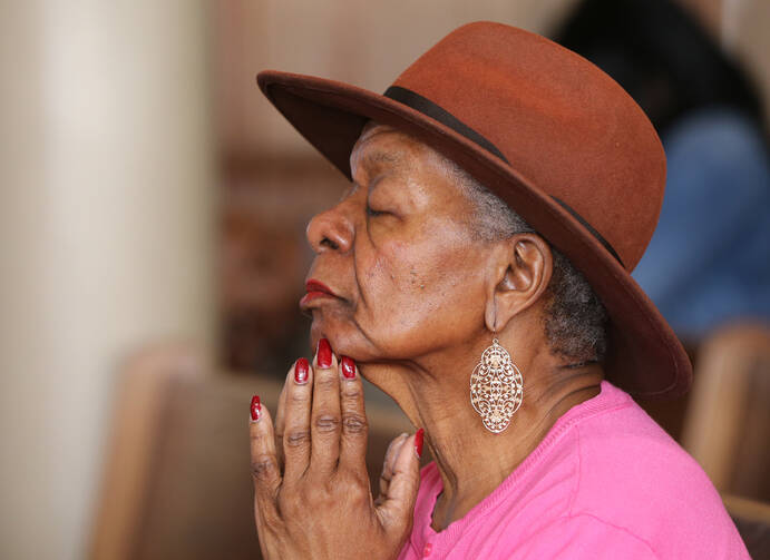 An elderly woman prays during Mass Nov. 13 at St. Peter Claver Church in Baltimore (CNS photo/Bob Roller). 